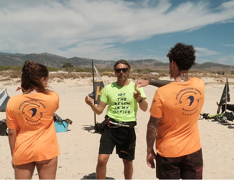 Instructor explicando una clase de kitesurf en Tarifa a un grupo reducido