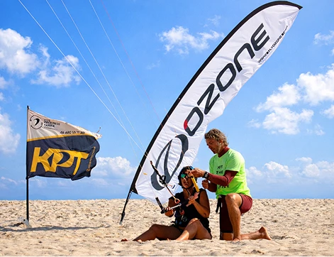 Instructor ayudando a una alumna durante una clase de kitesurf en Tarifa