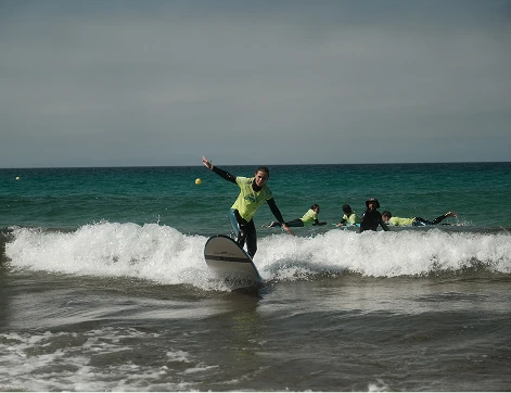 alumno cogiendo olas en curso de surf en Tarifa